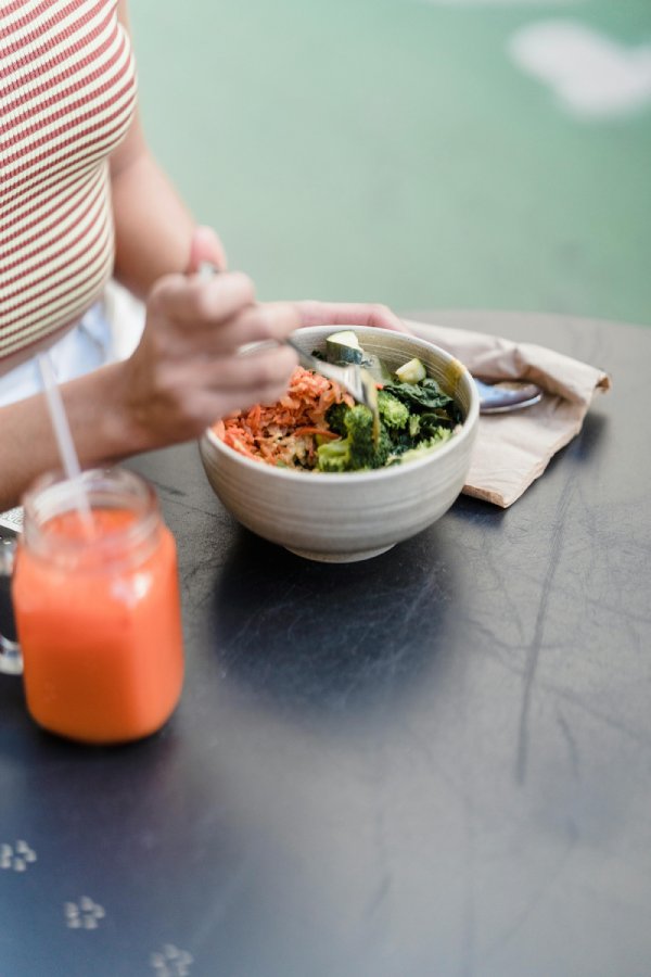 mujer comiendo ensalada con batido calabaza