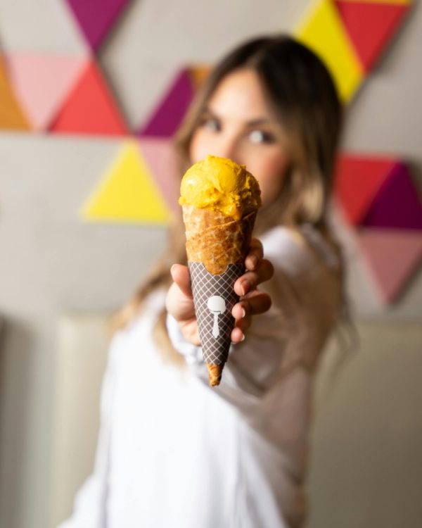 mujer enseñando helado naranja