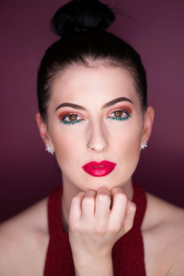 mujer con labios rojos y maquillaje colorido