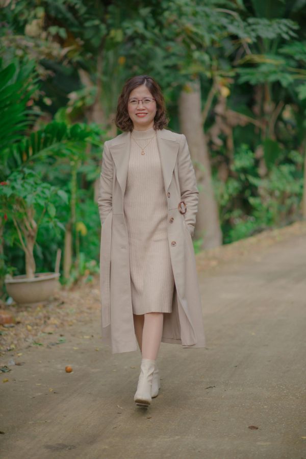 mujer paseando campo con gabardina y vestido