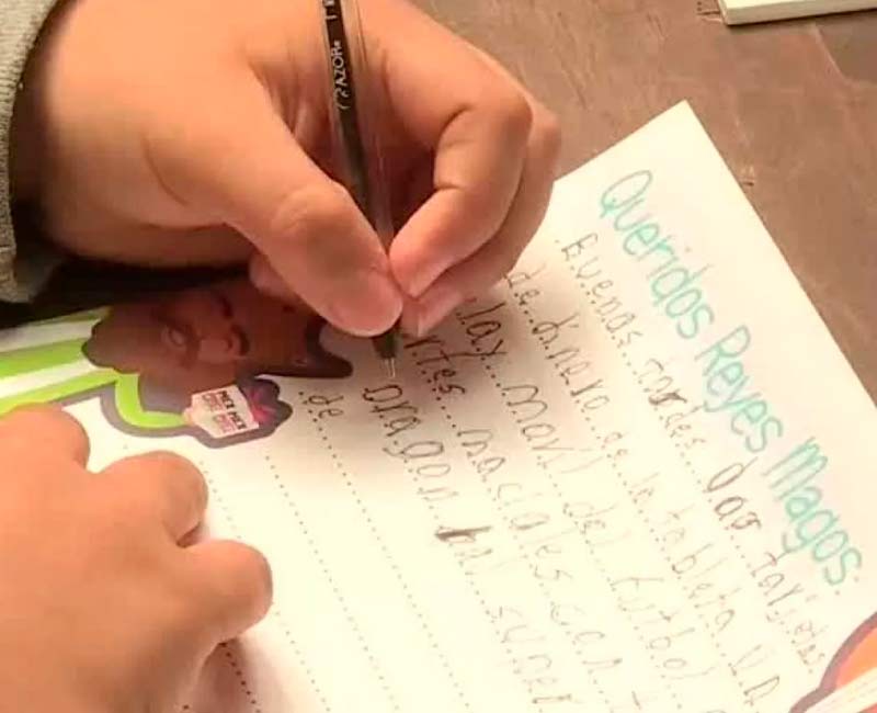 Niño escribiendo una carta a los Reyes Magos. Foto de Cultura Colectiva.