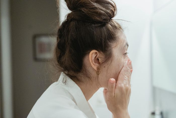 mujer lavándose la cara