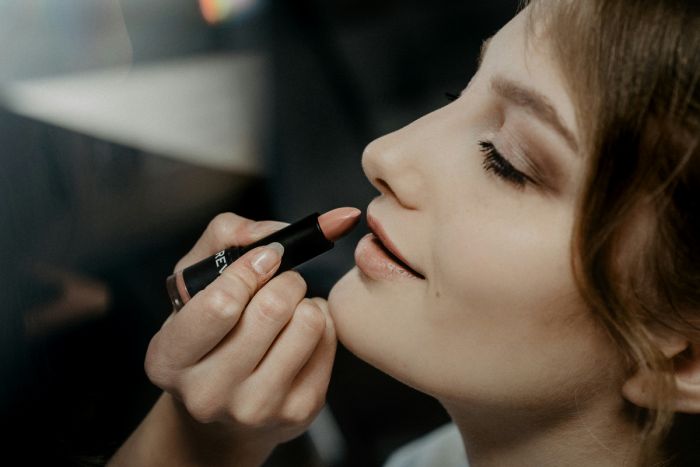 Mujer maquillándose los labios