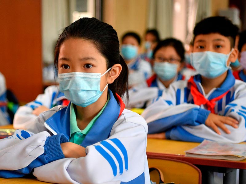Una de las medidas en la vuelta al colegio de los niños en China ha sido el uso de mascarillas.