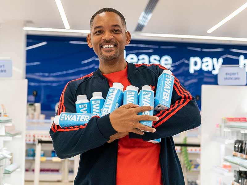 Will Smith llevando botellas de su marca de agua.