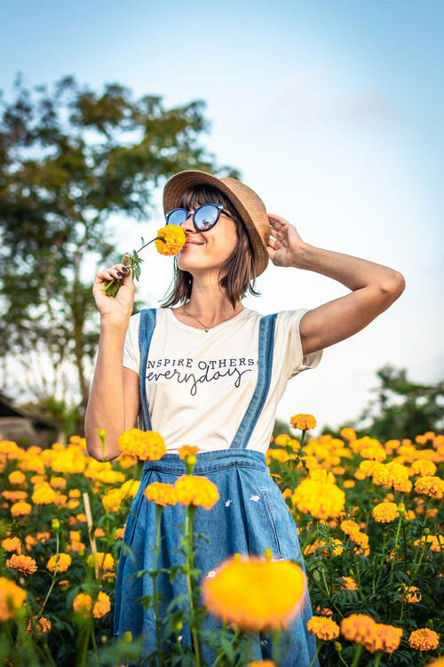 mujer oliendo flores