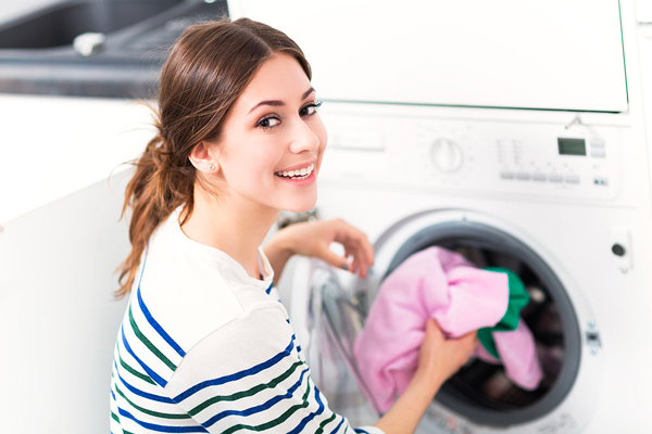 mujer sonriente poniendo la lavadora