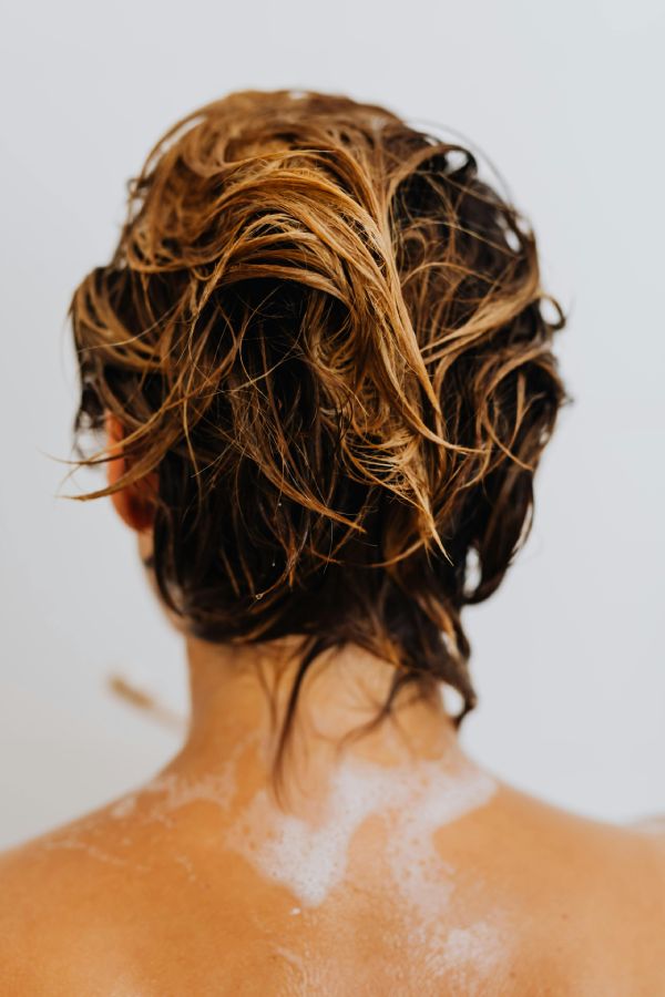 mujer con el pelo mojado y espuma