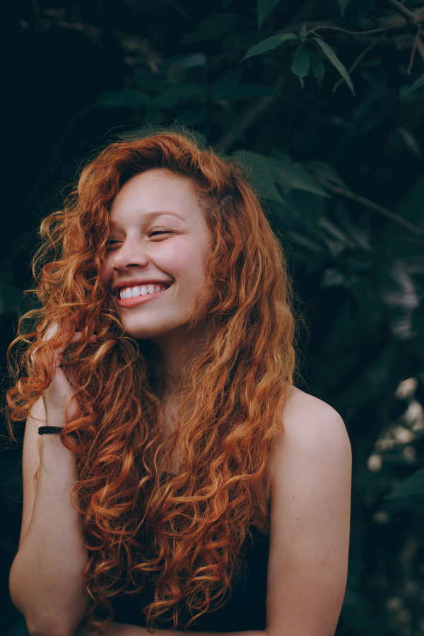 mujer sonriente de pelo rizado