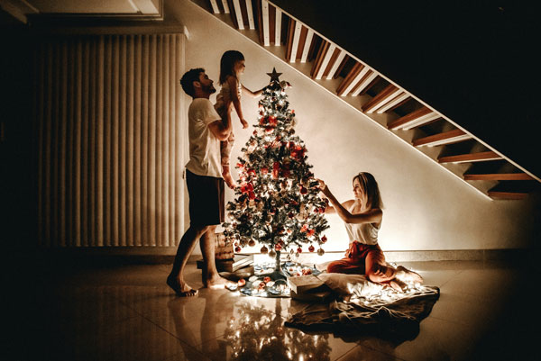 Imagen de una familia que decora el árbol de Navidad