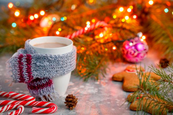 Imagen bebida navideña con bufanda y un árbol de Navidad