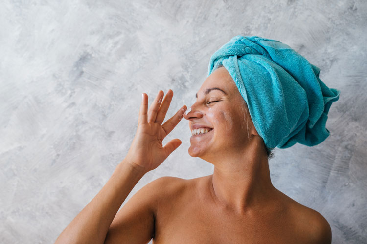 Limpiar la cara (bien)  mujer con toalla sonriente