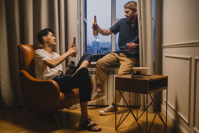 dos hombres jóvenes brindando con cerveza aperitivo tapeo