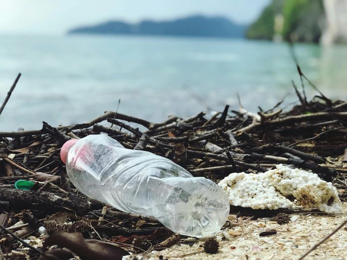 botella de plástico y residuos con vistas al mar reducir consumo de plásticos