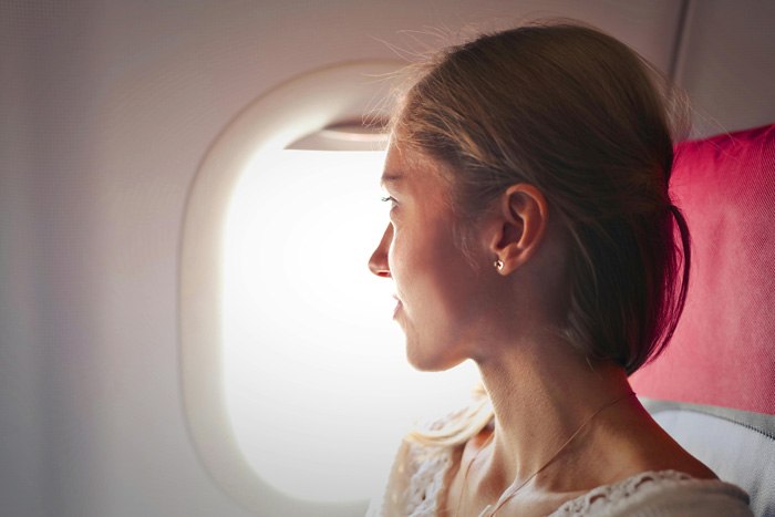 mujer mirando por ventanilla de avión