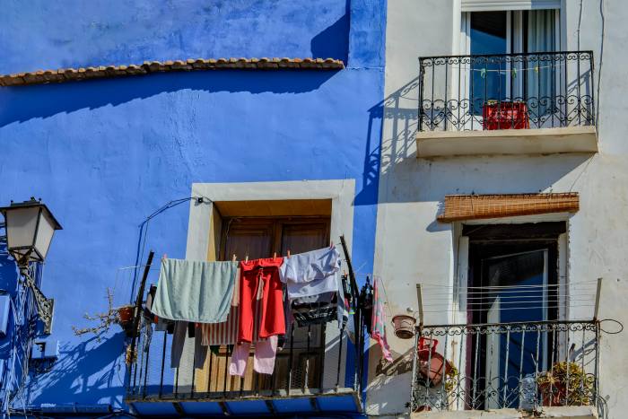 fachada azul con ropa tendida en la ventana
