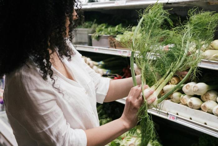 mujer comprando hinojo en el supermercado
